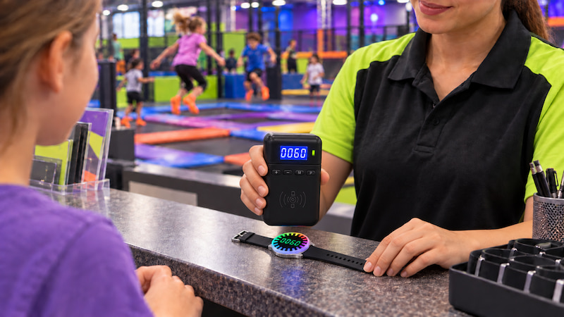 Staff setting a 60-minute session on a countdown wristband at a trampoline park