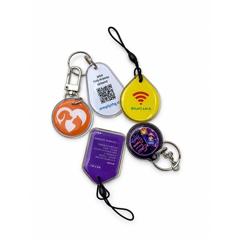 Custom yellow and blue epoxy key tags with clear sealed edges and black loops